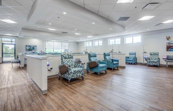 Spacious infusion treatment area with comfortable seating and lots of natural light