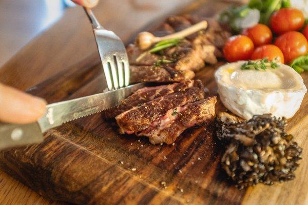 Rib-eye stead with arugula, olive oil and roasted tomatoes.