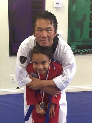 Master Kim with my daughter at a belt testing event