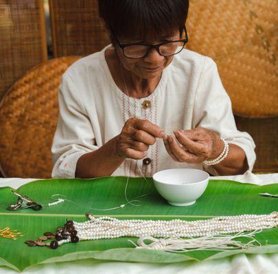 One of our Artisans, Pen, making our Self Love 4mm jewelry.