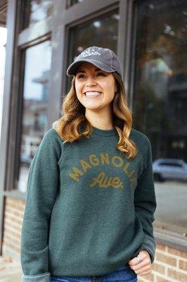 Woman in green magnolia Ave sweatshirt