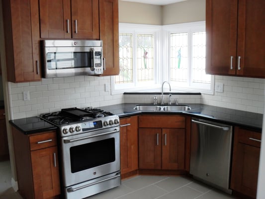 Brentwood Kitchen.  Features: Sandalwood finish/ Shaker style cabinets, black granite, white subway tiles.