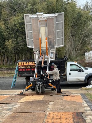 R2D2 depositing old roof shingles into their dump truck