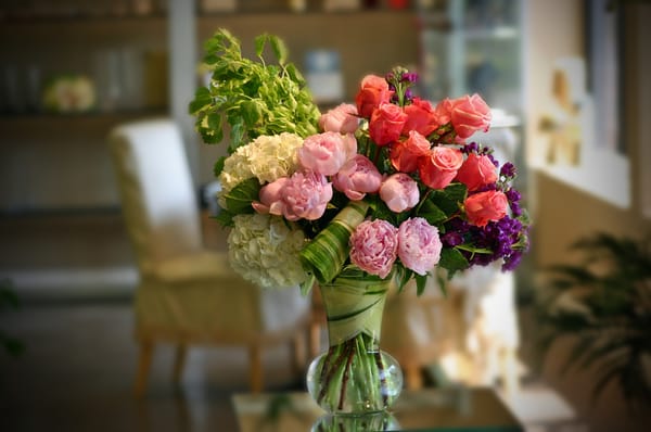 Vase filled with peonies, roses, hydrangea, bells of Ireland and fragarant stock professionally designed ready for delivery!