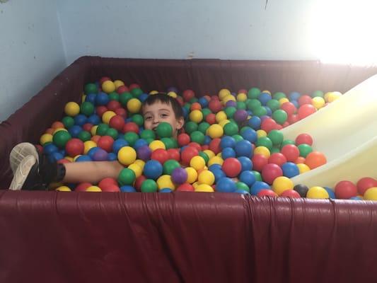 My son hiding in the ball pit.