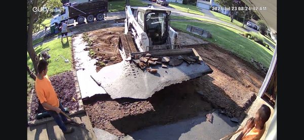 Being careful removing old asphalt around landscaping.