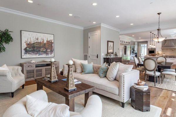 Modern living room with modern lighting, painted walls white rug, wooden floor and fully furnished.