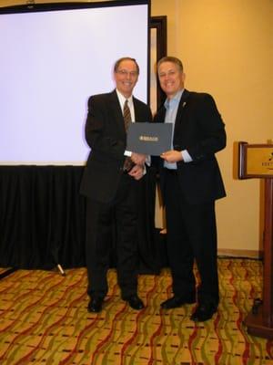 President Mike Filia receiving the award for Car Carrier of the Year from Paragon Relocation.