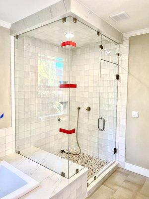 Frameless steam shower with movable transom above the door.