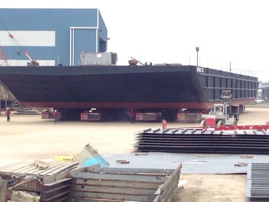 Rolling a partially erected barge to the drydock to complete construction.  Barge  is too heavy to finish on land