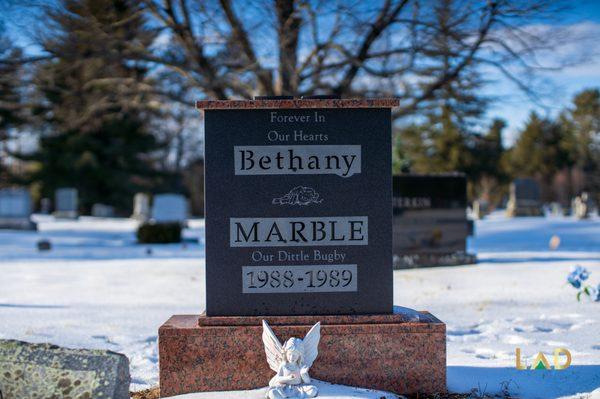 Bethany's two tone memorial headstone with a dove statue placed in front.