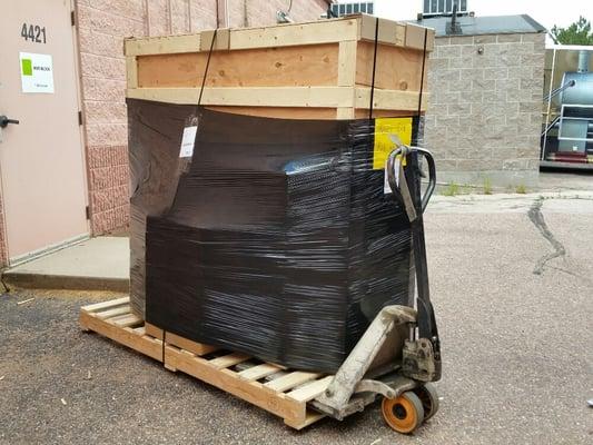 Crate and boxes on a pallet ready for pickup by an LTL carrier.