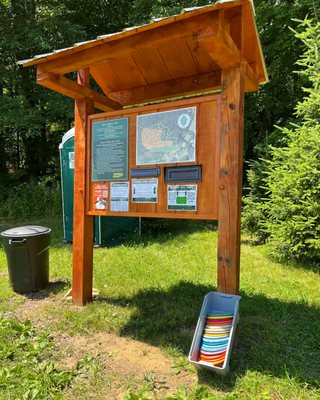 Trail head sign, payment information, loaner discs, garbage and portable potty located at course entrance.