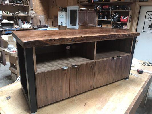 Walnut live edge top credenza, with storage for electronics. Metal leg bases.