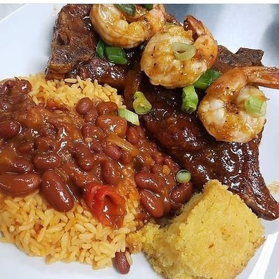 Jerked pork chop with jumbo shrimp, red rice and beans and corn bread