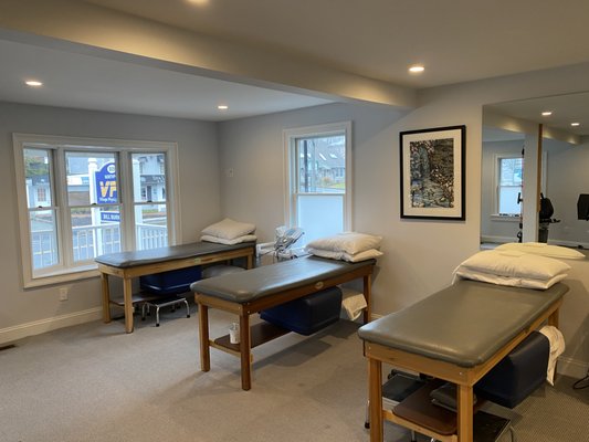 The main floor offers multiple treatment tables with modalities.