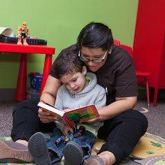 Teacher reading a book with a student