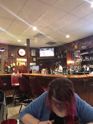 Bar front with one of the several tvs here with a ballgame on.