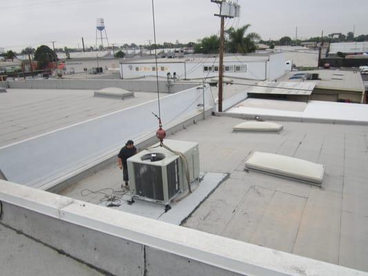 Setting 7.5 ton package unit on roof curb in Long Beach