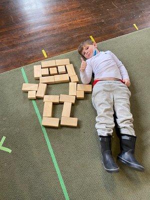 He built a person out of blocks then decided to measure himself against the block person. Who is bigger?