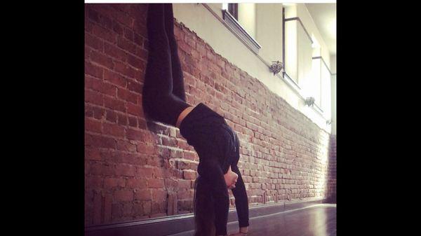 One of our instructors, Alison A, heels over head in love with the exposed brick walls. Come to her lunchtime 50min flow Thurs