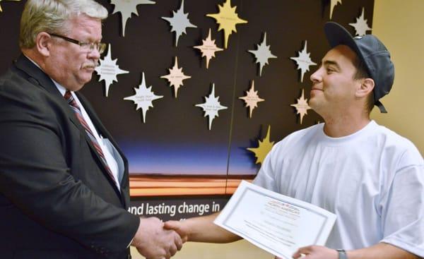 Genghis, an Apprenticeship Preparation Program graduate, receives his completion certificate