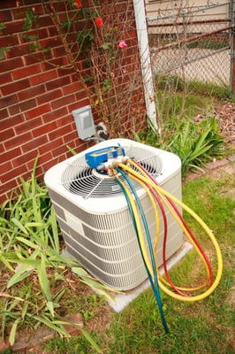 Technician getting ready to check pressures on condensing unit.