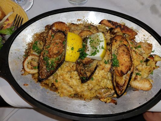 Paella with Risotto:  Mussels, clams, white fish of the day, calamari, chicken, sausage, bell peppers, snow peas, and saffron.