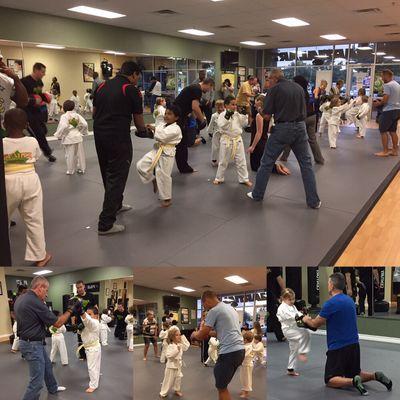 Children's working with their parent on their karate self defense moves