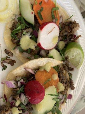 Tacos de carne asada with complimentary veggies and salsa verde