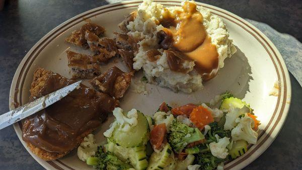 Chicken fried steak dinner smothered in brown gravy with mashed potatoes and veggies, very good!