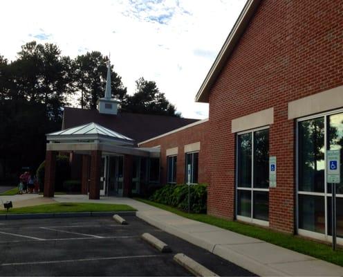 Front of church (also school entrance). Faces N Great Neck Rd across from John B Dey Elementary.