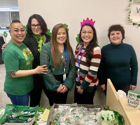 5 employees smile during Fedelta's St. Patrick's Day event