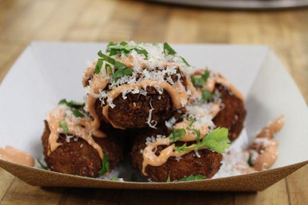 Arancini: fried risotto balls stuffed with gooey fontina, topped with parmesan and parsley and our fancy nana sauce.