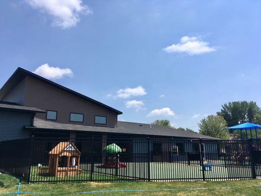 Large outdoor playground incorporates safe surface padding and natural grass play area.