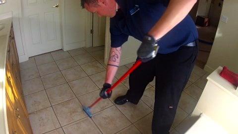 Scrubbing the grout during tile clean.