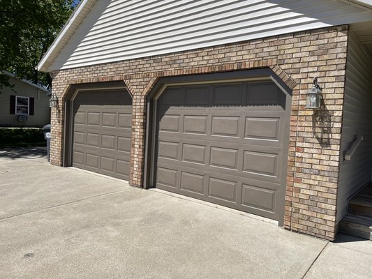 New siding, metal trim and new paint on garage doors.