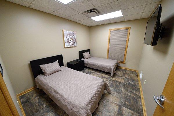 Well-appointed bedrooms at Parkman Recovery Center offer the comforts of home, including flat screen tv.