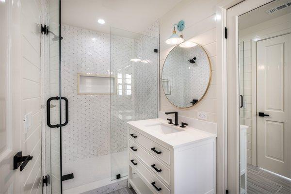 Bathroom renovation features new vanity, custom accent walls, new showers, hardware, recessed lighting, toto and tile flooring