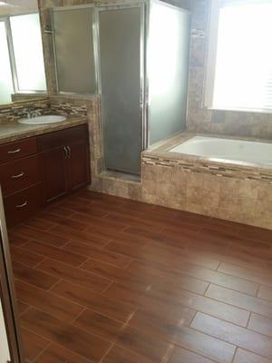 Wood Grain Tile Flooring, Tile Counter Top and Bathtub with Mosaic Accents