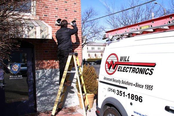 A tech finishing a camera install in the Central West End.