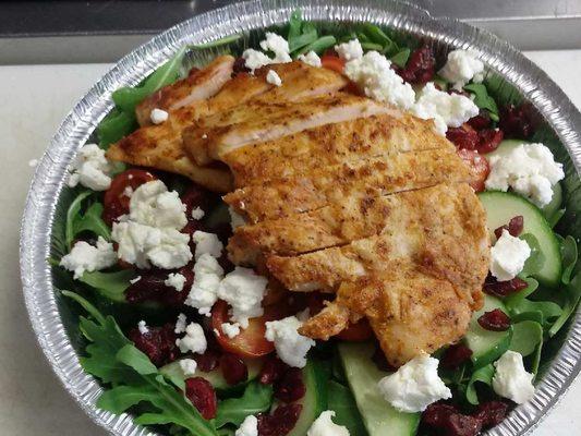 Cranberry Fusion Salad with Juicy Grilled Chicken, served over a bed of Arugula.