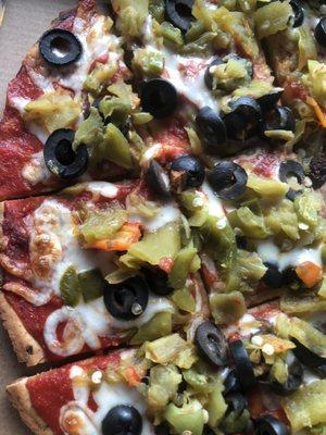 Cauliflower pizza with green chile, olives, and easy cheese.