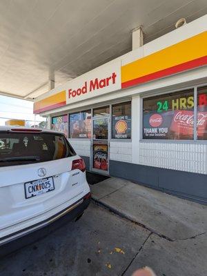 Outside the Food Mart convenience store. North entrance. "Welcome to Midtown" sign.