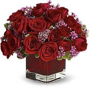 Sweet and Romantic, this is a sweet cube arrangement, filled with red roses and purple wax flower.