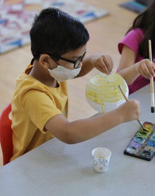 Painting paper lanterns to represent the planets during STEAM class!