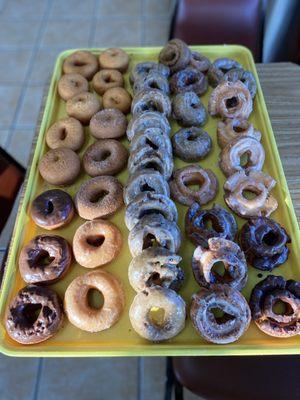 Assortment of cake donuts, such as blueberry, buttermilk, chocolate frosted cake donuts, and more