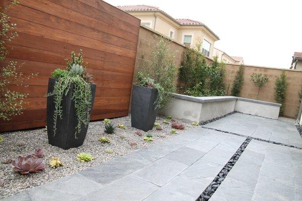 Redwood screen, modern planters, seat walls.