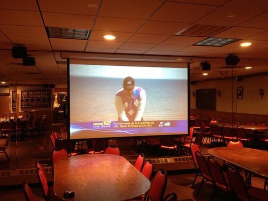 Automatic Projector Screen in a Hall.  Screen comes down by pushing a button on the wall