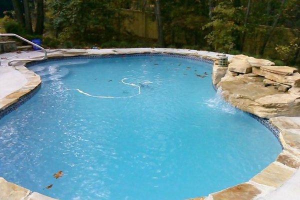 Beautiful Gunite pool with natural stone coping and baby blue plaster. Waterfall kit added.